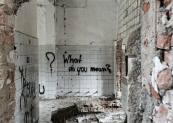 a dirty bathroom with graffiti on the walls